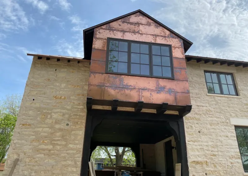 Copper metal panel facade on a stone building for Skylight Installation in Tomah
